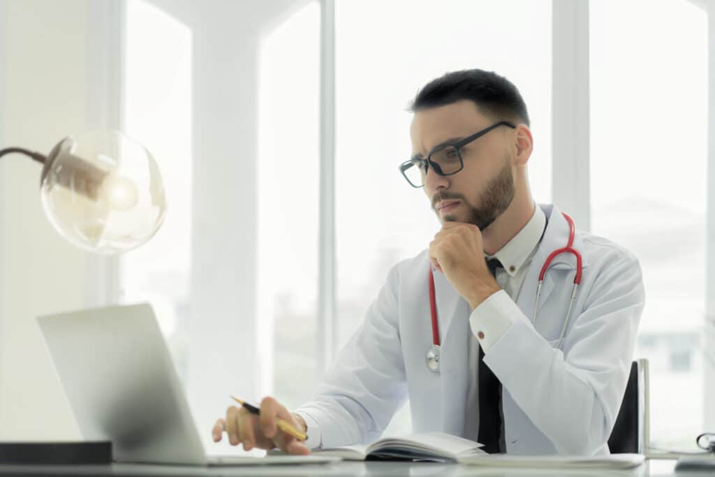 Healthcare provider reviewing EHR system features on a computer.