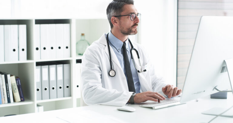 Cropped shot of a handsome middle aged male doctor using a computer while working in his office